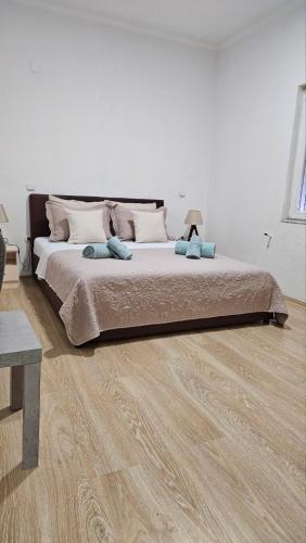 un letto grande in una camera da letto con pavimento in legno di Ramonda Apartment a Gevgelija