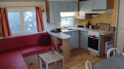 a small kitchen with a red couch in a room at Family mobile home solar powered near the sea and the airport in Áyios Spirídhon