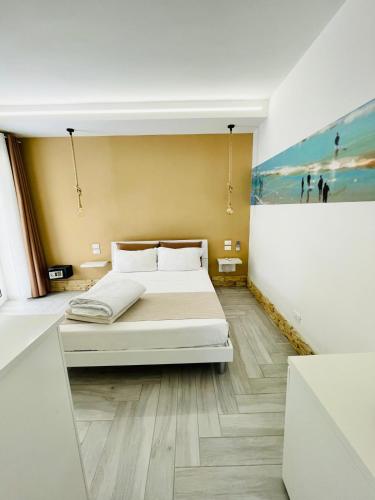 a bedroom with a bed and a painting on the wall at Aquamarì Charme Rooms in Vieste