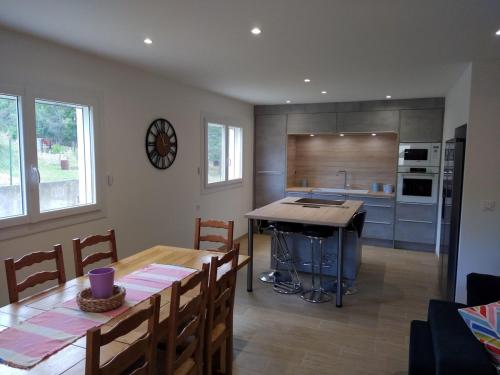 une cuisine et une salle à manger avec une table et un comptoir dans l'établissement Villa au pieds des Gorges de l'Ardèche, à Laval-Saint-Roman