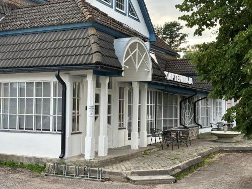 a white and blue house with a table on the porch at Captains House - Kaptenimaja - Officers deck in Kärdla