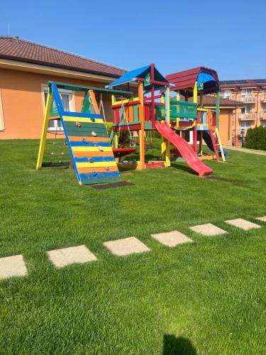 a playground with colorful play equipment on the grass at Villa Gracia Podhájska in Podhájska