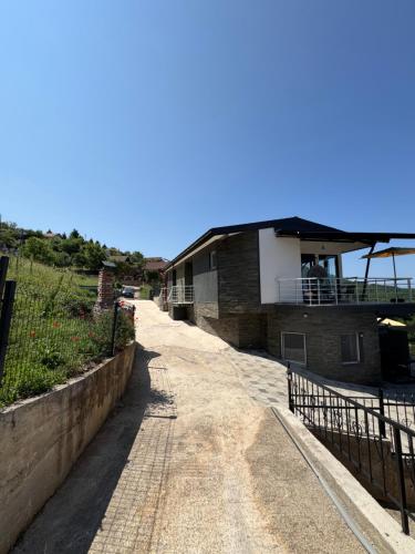 a building with a fence on the side of a road at Velestovo Panorama House in Velestovo