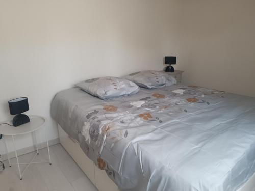 un lit avec deux oreillers dessus dans une chambre dans l'établissement Maisonnette dans hameau provençal, à Cabriès