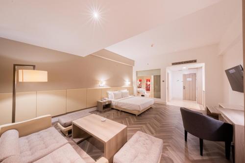 a large living room with a bed and a couch at Grand Jatra Hotel Balikpapan in Balikpapan