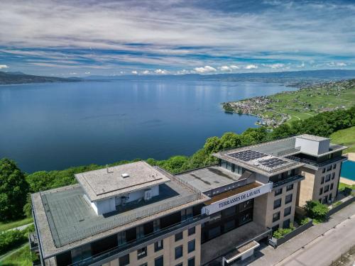 an aerial view of a building next to a body of water at Les Terrasses de Lavaux-2 Appartement de Luxe avec Vue Panoramique et Piscine" in Chexbres