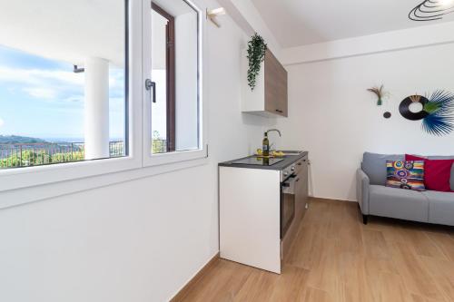 a kitchen with a couch and a window in a room at Granatelli Holiday Home in Altavilla Milicia