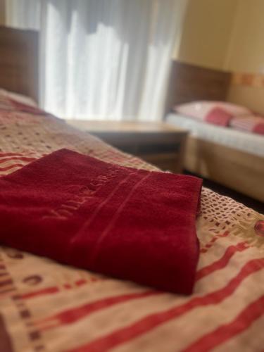 a red blanket sitting on top of a bed at Villa Gracia Podhájska in Podhájska