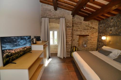 a bedroom with a bed and a tv in a room at Rooms in Spello in Spello