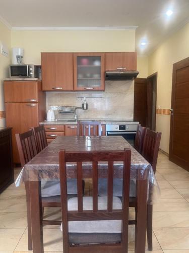 a kitchen with a wooden table with chairs and a kitchen with a stove at Villa Gracia Podhájska in Podhájska