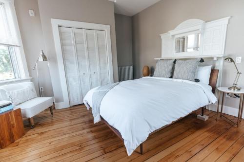 a bedroom with a large white bed and wooden floors at CHIC Thames Harbor free parking in Newport