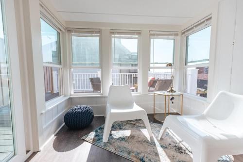 a room with two white chairs and windows at CHIC Thames Harbor free parking in Newport