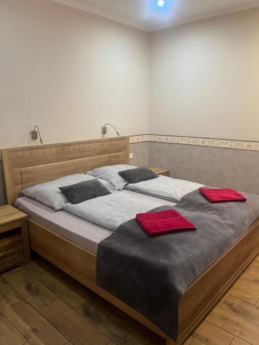 a bedroom with a bed with two red towels on it at Villa Gracia Podhájska in Podhájska