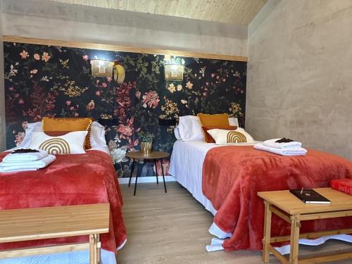 a bedroom with two beds and a floral wallpaper at Tibo - Casal do Conde in Caldas de Reis