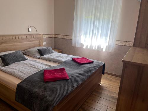 two beds in a bedroom with red towels on them at Villa Gracia Podhájska in Podhájska