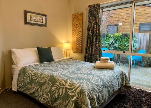 メスベンにあるSweet Methven Getaway - Two Bedroom Apartmentのベッドと大きな窓のある寝室