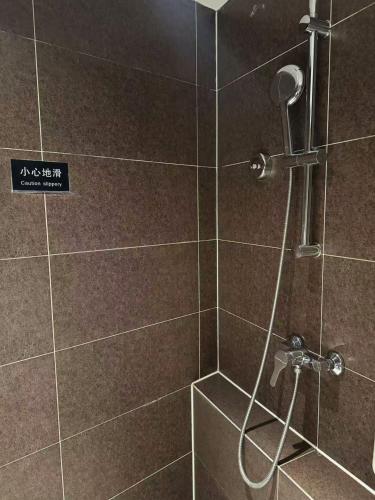 a bathroom with a shower with a glass door at Atour Hotel Qingdao Olympic Sailing Center May Fourth Square in Qingdao