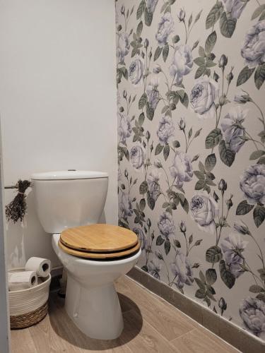 La salle de bains est pourvue de toilettes et de papier peint à fleurs. dans l'établissement Maison Essentielle, à Tournon-sur-Rhône