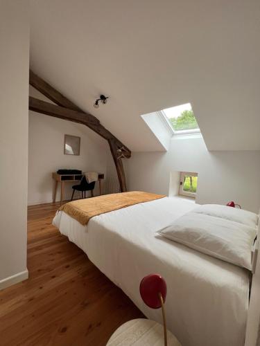 une chambre avec un grand lit avec une lucarne dans l'établissement Lac de Vassivière Petite maison à proximité, à Saint-Julien-le-Petit