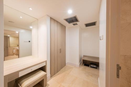a bathroom with a sink and a mirror at Grand Jatra Hotel Balikpapan in Balikpapan