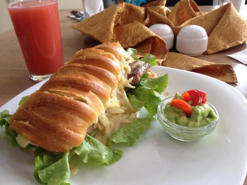 a plate of food with a sandwich and a salad at Hotel de las Américas - Ambato in Ambato