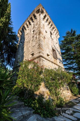 a tall brick tower with bushes in front of it at Exclusive 15th century castle, between Cinque Terre and Portofino, offering complete privacy and a private infinity pool in Leivi