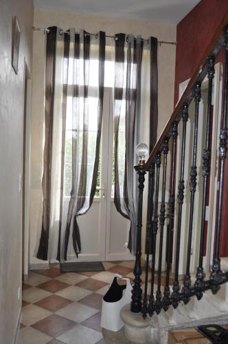 a room with a staircase and a door with curtains at Chambres d'Hotes La Mouline in Ludon-Médoc