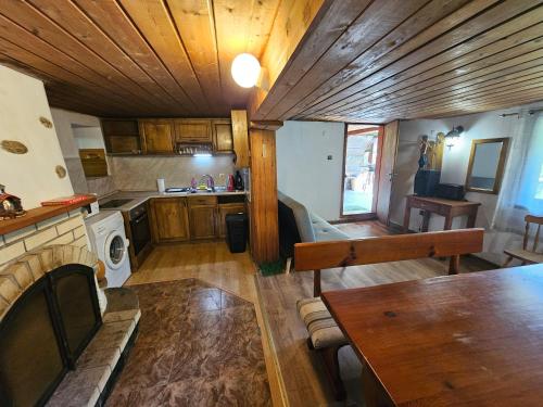 a kitchen with wooden cabinets and a table in a room at Къща за гости Хитър Петър in Apriltsi