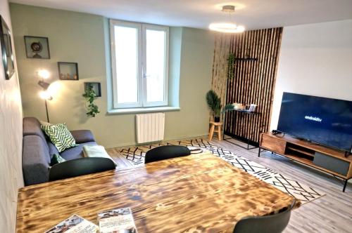 un salon avec une table et une grande télévision dans l'établissement New Triplex Casanna Vieille Ville, à Pont-à-Mousson