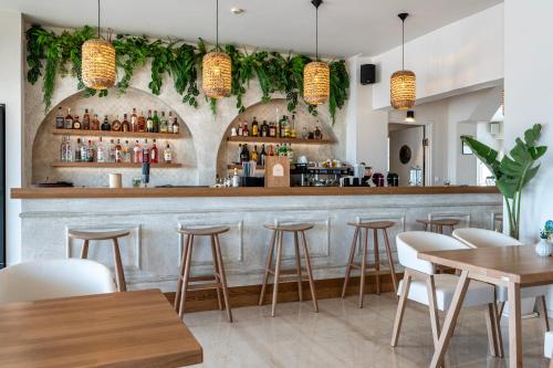 a bar in a restaurant with tables and stools at Zephyros Hotel in Kos Town