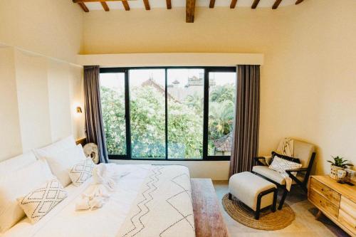 a bedroom with a bed and a large window at Villa KHAYA Seminyak Stylish 2-Bedroom Villa Just 900m from the Beach in Badung