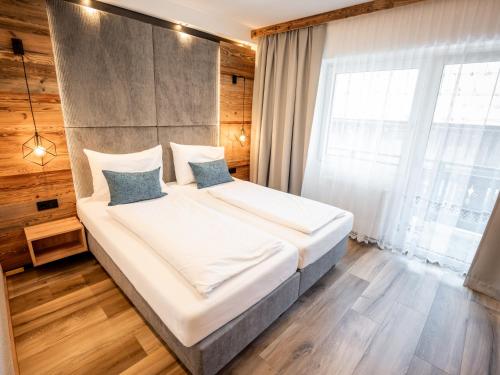 a bedroom with a large bed with white sheets and blue pillows at Gasthof Gosauschmied in Gosau