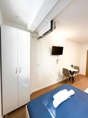 a bedroom with a bed and a desk and a tv at Modern Central Studio - 3 min walk to lake in Ohrid