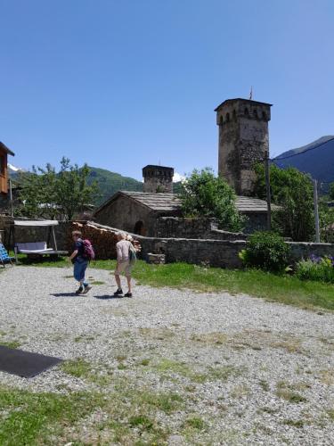 two people are standing in front of a building at Bapsha Guesthouse in Mestia