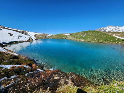 a blue lake in the middle of a snowy mountain at Chalet 6 à 8pers pied des pistes, piscine et vue in Saint-François-Longchamp
