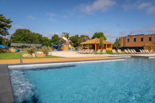 a swimming pool with a water park in the background at Vakantiepark Leukermeer in Well