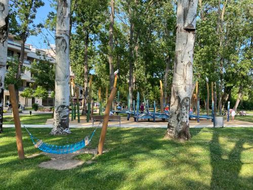 a hammock in a park with trees at Nekem Füred in Balatonfüred