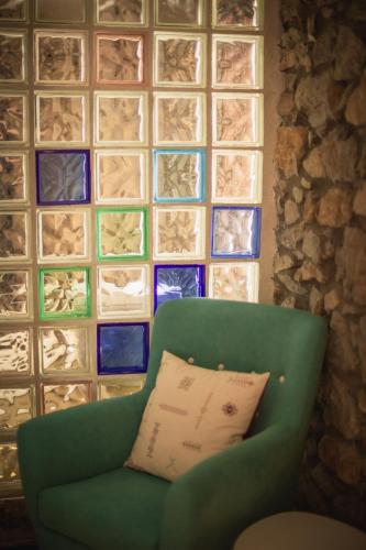 a green chair with a pillow in front of a wall at La Joyuca Del Pas in Mogro