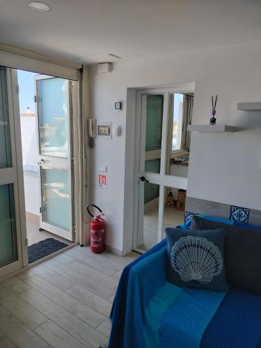 a bedroom with a blue bed and a balcony at Attichetto monolocale vista mare terrazzatissimo Asterspace in Anzio