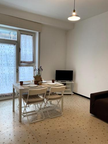 a living room with a table and chairs and a tv at Cà di Scirocco in Varigotti