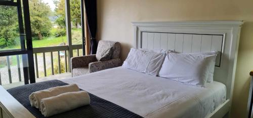 a bedroom with a bed and a chair and a window at Alpine Chalets in National Park