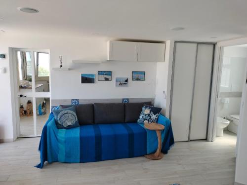 a living room with a blue couch in a room at Attichetto monolocale vista mare terrazzatissimo Asterspace in Anzio