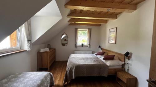 a bedroom with two beds in a attic at U Křížku - Chalupa s duší in Desná