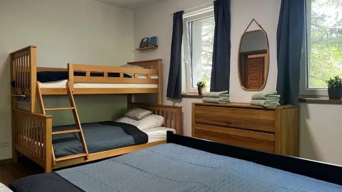 a bedroom with two bunk beds and a mirror at U Křížku - Chalupa s duší in Desná