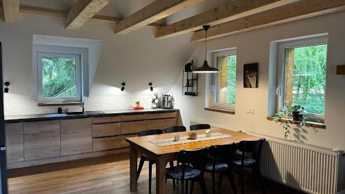 a kitchen and dining room with a wooden table and chairs at U Křížku - Chalupa s duší in Desná