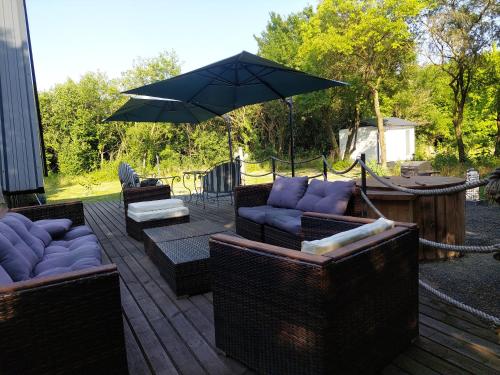 a patio with three couches and an umbrella at Farm Ház in Fonyód