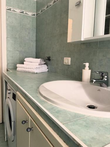 a bathroom with a sink and a washing machine at Cà di Scirocco in Varigotti