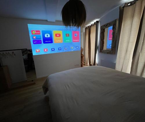 a bedroom with a bed and a large screen at Cocon Jungle Hyper Centre in La Côte-Saint-André