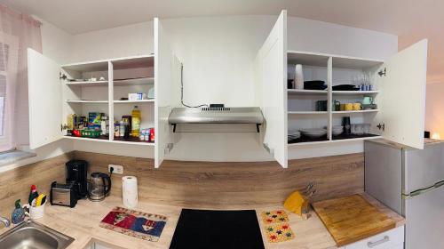 a kitchen with white cabinets and a sink at Holiday Apartment in Mörfelden-Walldorf in Mörfelden-Walldorf