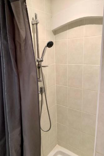 a shower with a shower curtain in a bathroom at Les Flots de Ver in Ver-sur-Mer